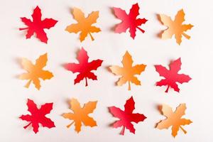 feuilles d'érable orange et rouges découpées dans du papier kraft en rangées. décoration d'automne. photo