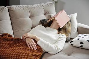 femme dort sur un canapé avec un livre photo
