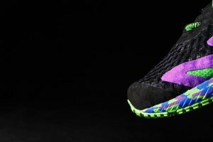 baskets de sport multicolores sur fond noir. photo