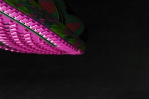 semelle rose texturée de chaussures de course de sport sur fond noir. photo