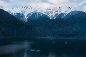 lac d'hiver ritsa en abkhazie avec des montagnes dans la neige en arrière-plan, tard dans la soirée. photo