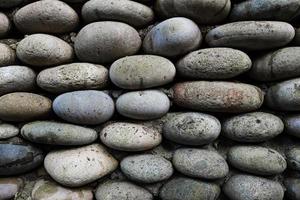la texture du mur de pierre, maçonnerie de pierres ovales naturelles. photo