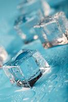 les glaçons sont parsemés de gouttes d'eau éparpillées sur un fond bleu. fermer. photo