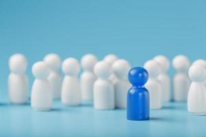 le leader de la couleur bleue se tient parmi la foule, un groupe d'employés blancs. la notion de leadership. de nombreux employés sont attirés par leur patron. sélection du personnel. photo