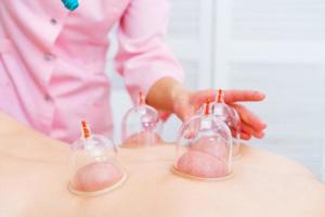 jeune femme détendue recevant la mise en conserve sur le dos au spa. massage sous vide. femme photo