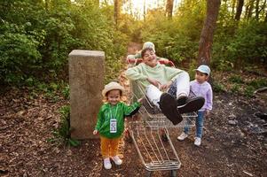 enfants avec chariot s'amusant en forêt. photo