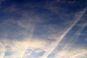 Contraintes de condensation des avions dans le ciel bleu entre quelques nuages photo