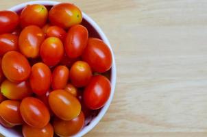 tomates cerises rouges fraîches dans un bol en céramique blanche photo