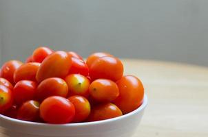 tomates cerises rouges fraîches dans un bol en céramique blanche photo