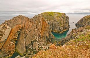 roches déchiquetées colorées sur une côte de l'océan photo