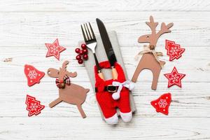 vue de dessus des ustensiles du nouvel an sur une serviette avec des décorations de vacances et des rennes sur fond en bois. gros plan du concept de dîner de noël photo