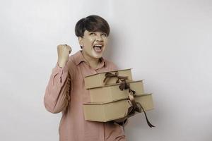 une jeune femme heureuse porte une chemise rose et tient des cadeaux ou un sac à provisions. photo