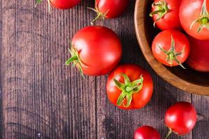 tomates biologiques mûres sur une table en bois. récolte et produits locaux. vue de dessus