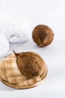 deux noix de coco mûres entières sur la table. fruits tropicaux. vue verticale photo