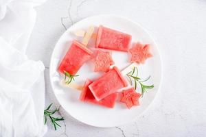 glace à la pastèque et morceaux de pastèque sur une assiette sur la table. dessert maison. vue de dessus photo