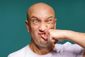 portrait d'un homme chauve se frappe sur la joue, expressions faciales photo