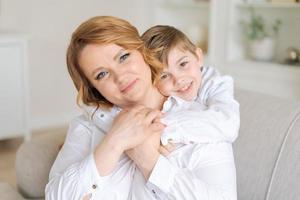 petit fils félicite maman pour la fête des mères à la maison, femme heureuse mère photo