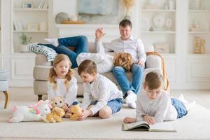 les parents caucasiens heureux se détendent sur un canapé confortable dans le salon à la maison. petit photo