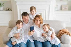 heureux joyeux caucasien famille papa maman et enfants s'amusant et utilisant le numérique photo