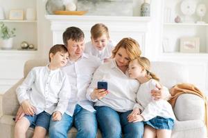 famille caucasienne assise sur un canapé dans le salon à la maison. mère père petit photo