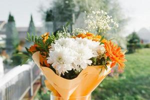 un bouquet festif de chrysanthèmes blancs et de gerberas orange pour un anniversaire ou un mariage photo