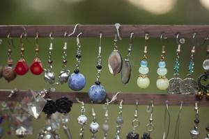 les boucles d'oreilles pour femmes sont vendues dans la rue. décoration pour fille en vitrine. boucles d'oreilles maison. photo