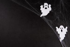 toile d'araignée avec des fantômes blancs sur fond noir photo