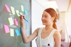 Asian girl writing roadmap planning on sticky note work at office photo