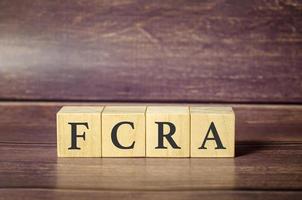 fcra - fair credit reporting act, mot écrit sur des blocs de bois sur une table en bois. photo