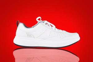 baskets blanches isolées sur fond rouge. nouvelle chaussure de sport sans marque photo