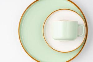 un ensemble de vaisselle en céramique blanche et vert pastel aux contours orange photo