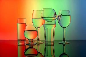 quelques verres pour différentes boissons empilés sur un fond coloré photo