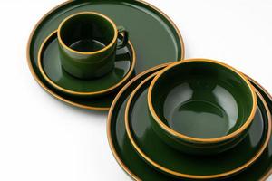 un ensemble de vaisselle en céramique vert foncé avec des contours orange sur fond blanc photo