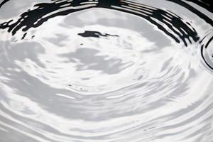 des gouttelettes d'eau ou des perles d'eau tombent à la surface de l'eau, provoquant la dispersion et la mousse de la surface de l'eau. photo