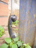 un ancien type de poignée de téléphone isolé dans un parc abandonné. une sorte d'ère du téléphone en 1990 photo