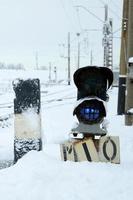 le sémaphore est situé sur l'autoroute traversant la voie ferrée en hiver photo