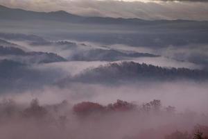 Brouillard matinal de couleur rouge sur les montagnes enfumées