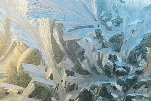 fenêtre d'hiver gelée avec texture de motif de givre brillant. symbole de merveille de noël, arrière-plan abstrait. extrême nord basse température, neige glacée naturelle sur verre givré, temps d'hiver frais à l'extérieur. photo