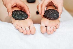 massage des pieds aux pierres chaudes. photo