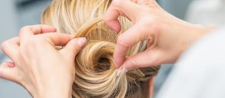 coiffeur faisant la coiffure de mariage de la mariée photo