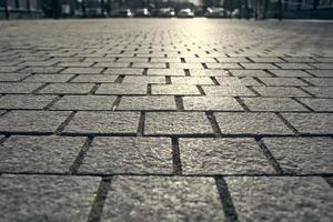 fond de carreaux de pavage. dalles de pavage en gros plan sur le fond des voitures dans le flou. photo