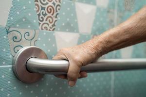 Une patiente asiatique âgée ou âgée utilise la sécurité de la poignée de la salle de bain des toilettes dans la salle d'hôpital de soins infirmiers, concept médical solide et sain. photo