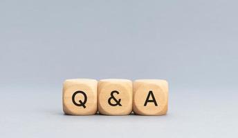 q et a ou concept de questions et réponses. texte sur des blocs de cube en bois sur fond gris photo