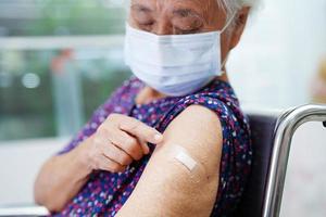 femme aînée asiatique se faisant vacciner pour protéger le virus corona.