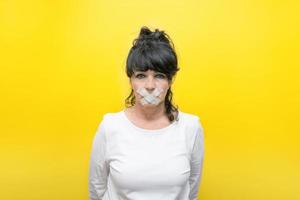 femme âgée avec une bouche scellée sur fond jaune, le concept de censure, interdiction photo