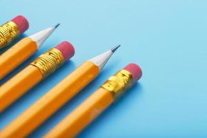 crayons orange avec une gomme sur fond bleu. photo