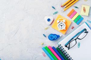 la papeterie scolaire se trouve sur un fond texturé gris avec de l'espace libre. photo