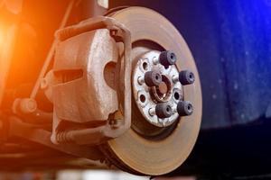 système de disque de frein sans roue sur une chandelle en attente de réparation dans les ateliers de réparation automobile. photo