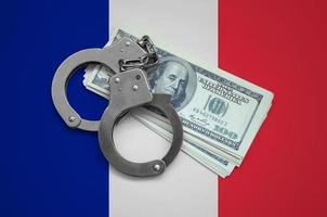 drapeau de la france avec des menottes et un paquet de dollars. la corruption monétaire dans le pays. crimes financiers photo