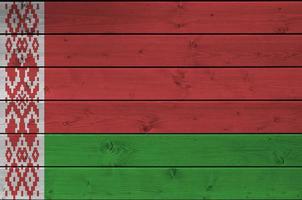 drapeau de la biélorussie représenté dans des couleurs de peinture vives sur un vieux mur en bois. bannière texturée sur fond rugueux photo